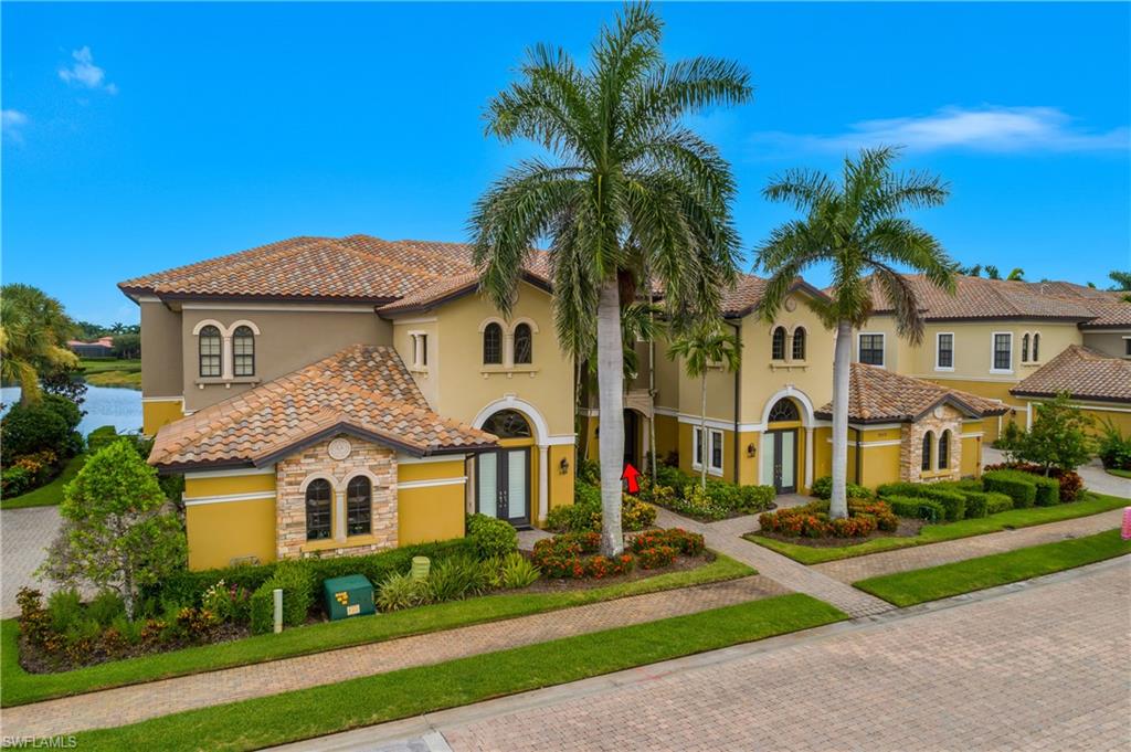 9109 Prima Way, Unit 102 Naples, FL 34113 - Photo 33 of 50 a front view of a house with a yard