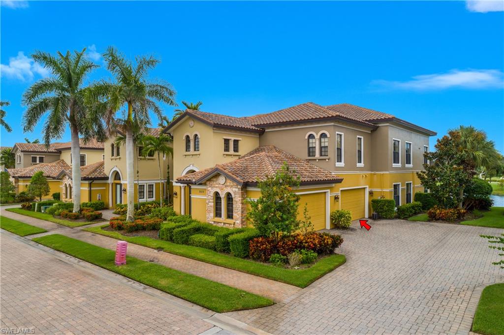 9109 Prima Way, Unit 102 Naples, FL 34113 - Photo 35 of 50 a front view of a house with a garden and plants