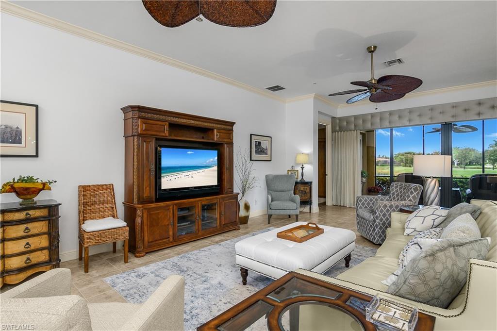 9109 Prima Way, Unit 102 Naples, FL 34113 - Photo 4 of 50 a living room with furniture and a flat screen tv