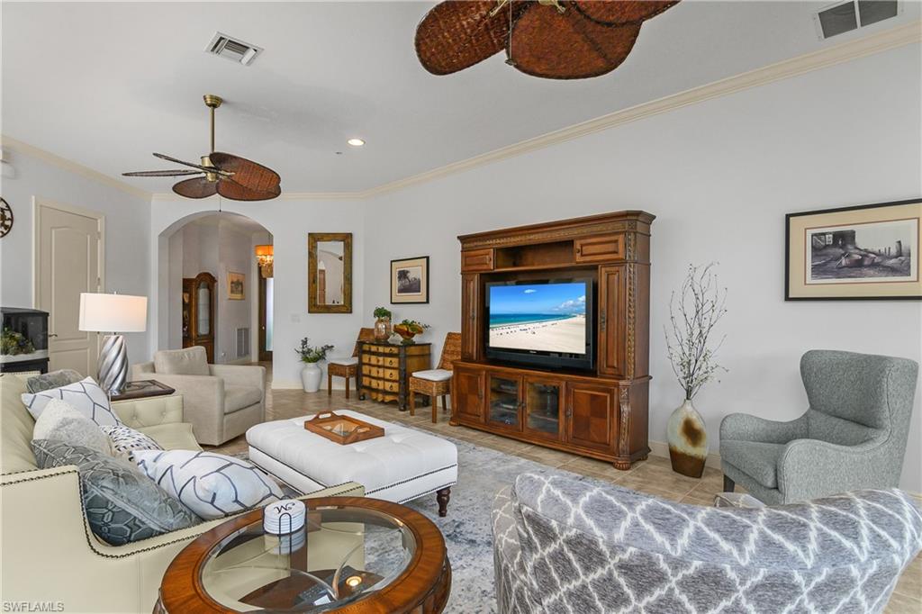 9109 Prima Way, Unit 102 Naples, FL 34113 - Photo 5 of 50 a living room with furniture and a flat screen tv