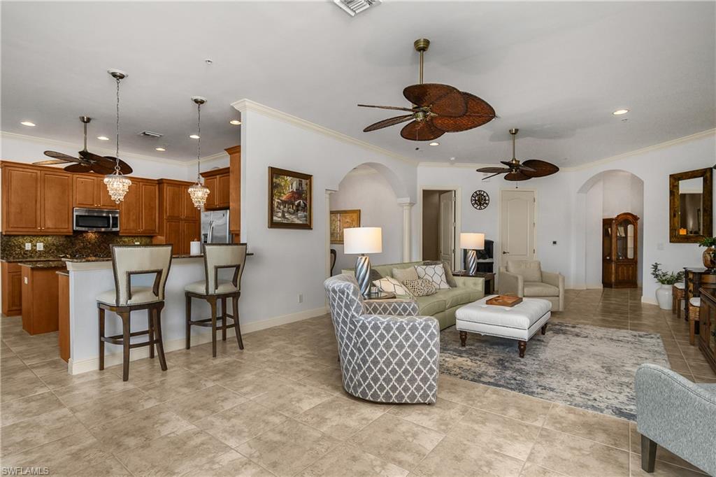 9109 Prima Way, Unit 102 Naples, FL 34113 - Photo 7 of 50 a living room with furniture kitchen view and a chandelier