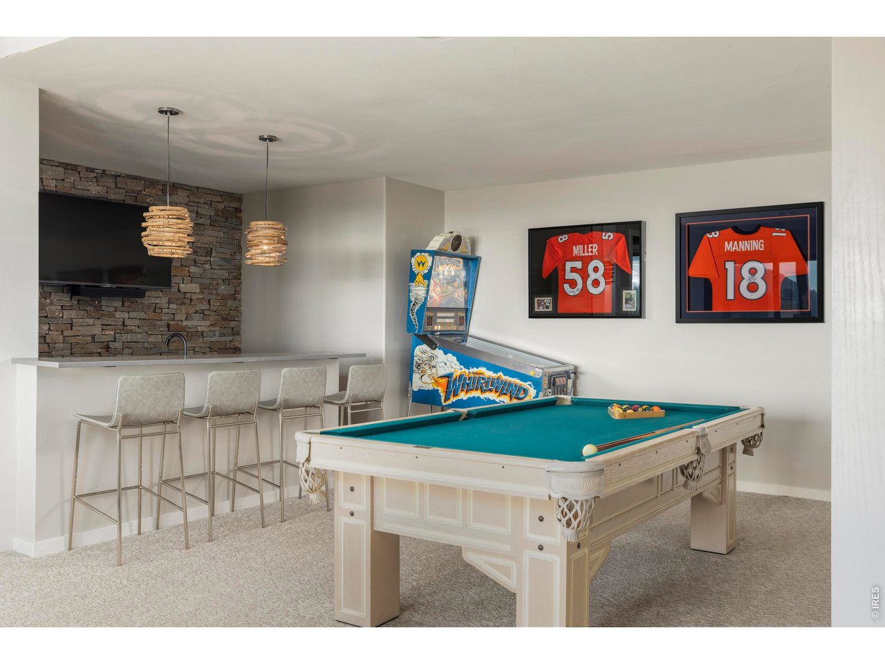 150 Valley View Way Boulder, CO 80304 - Photo 30 of 36 Downstairs, a spacious recreation room expands possibilities for movie nights or game days, while the adjacent bar with stone accent wall creates a complete entertaining zone.