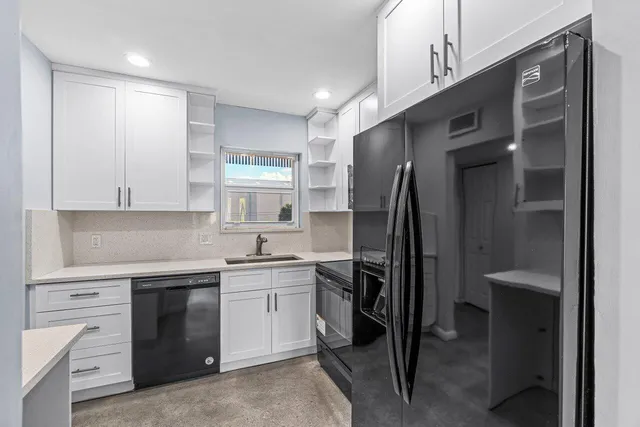 a kitchen with a sink stainless steel appliances and cabinets