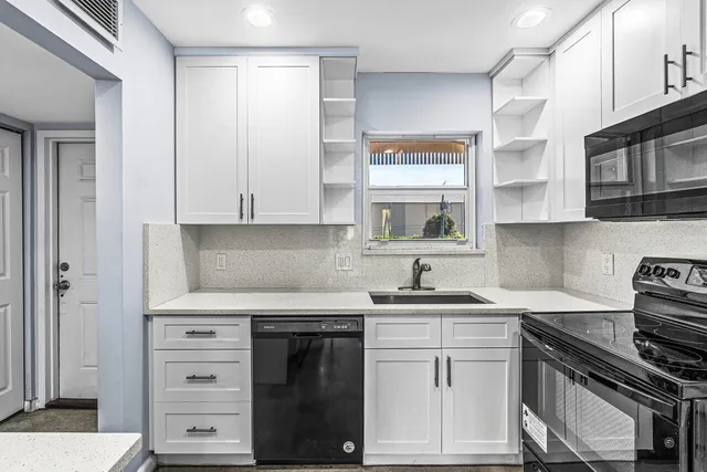 a kitchen with white cabinets and appliances