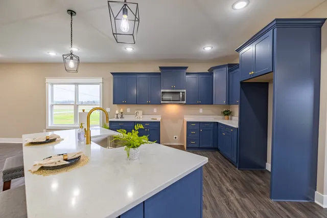 a kitchen with stainless steel appliances granite countertop wooden floors wooden cabinets a center island and appliances