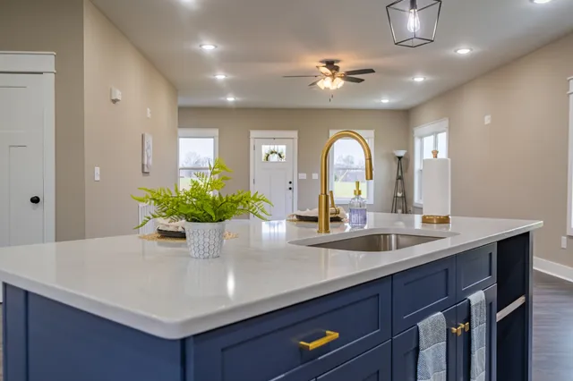 a kitchen with stainless steel appliances granite countertop wooden cabinets a sink and dishwasher with wooden floor