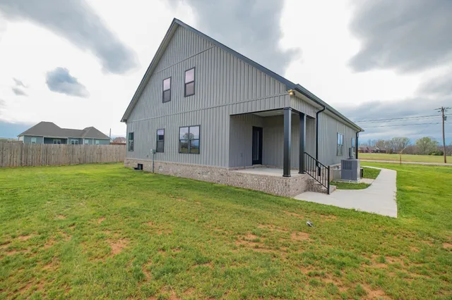 a view of a house with backyard and sitting area