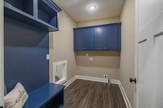a view of an empty room with wooden floor and a ceiling fan