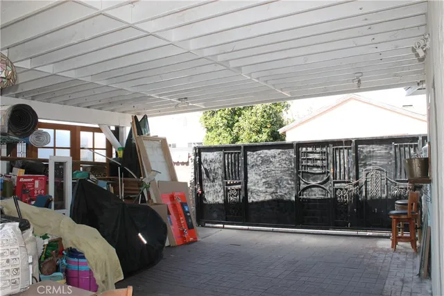 a backyard of a house with table and chairs potted plants and a large tree
