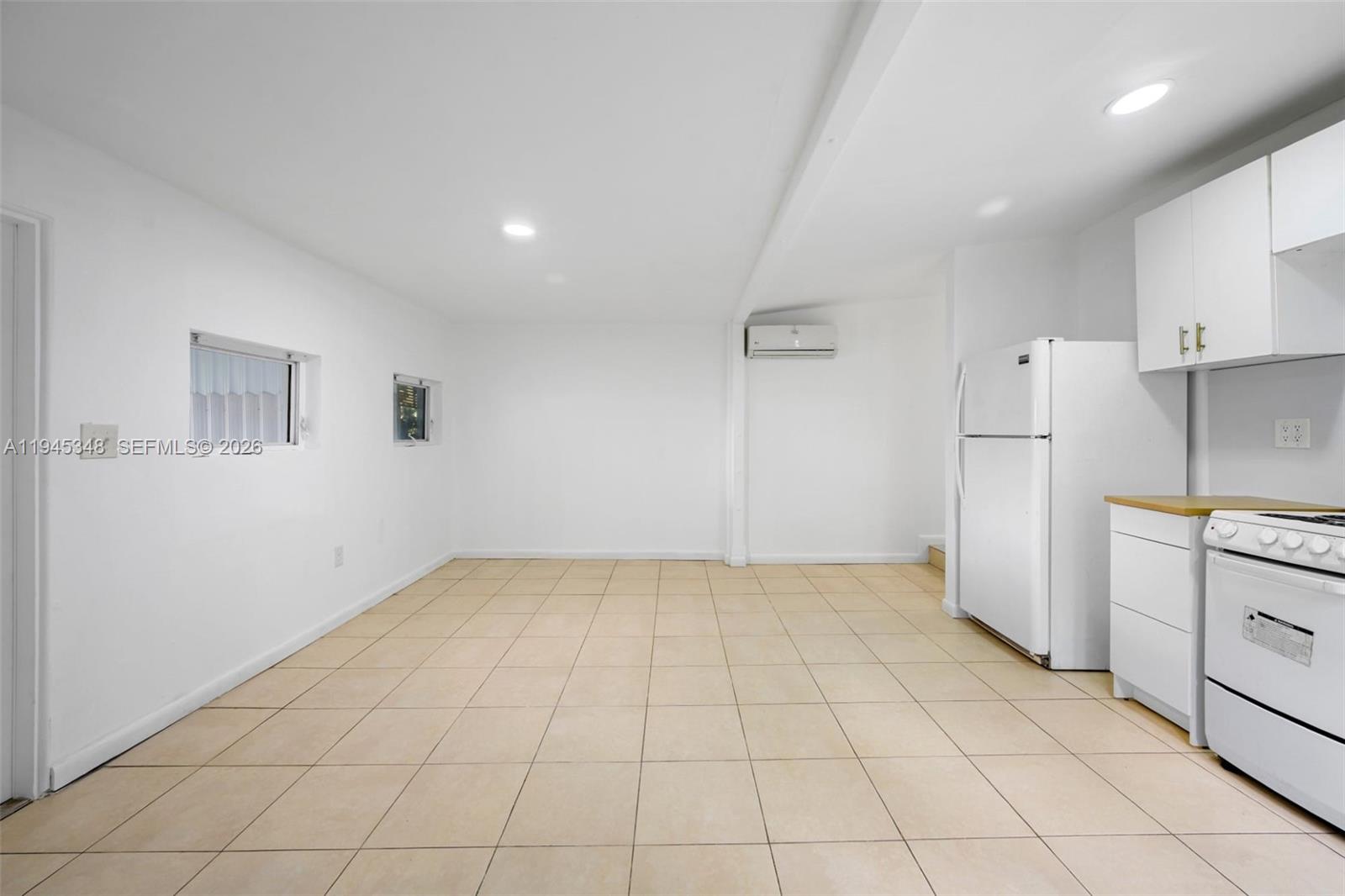 348 Northeast 58th Street Miami, FL 33137 - Photo 10 of 16 a view of a kitchen with white cabinets and refrigerator