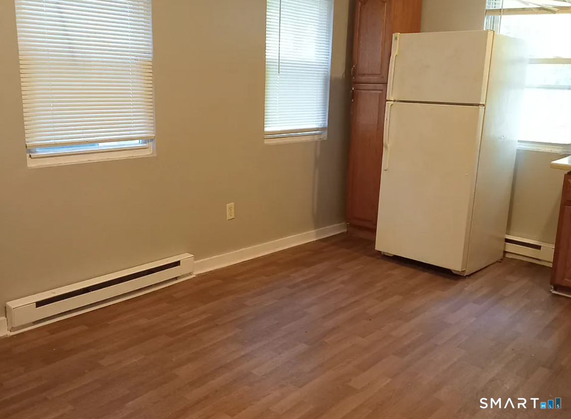 88 Olive Street Meriden, CT 06450 - Photo 4 of 7 an empty room with wooden floor and windows