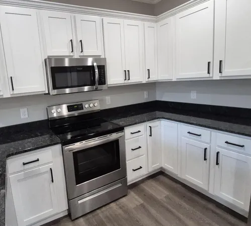 a kitchen with white cabinets stainless steel appliances and sink