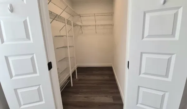 a view of a hallway with a white walls and wooden floor
