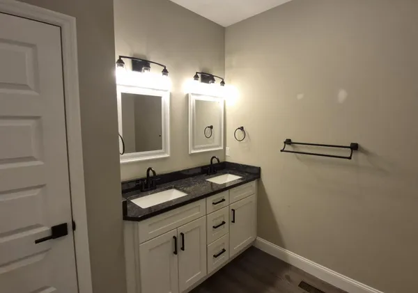 a bathroom with a granite countertop sink and a mirror