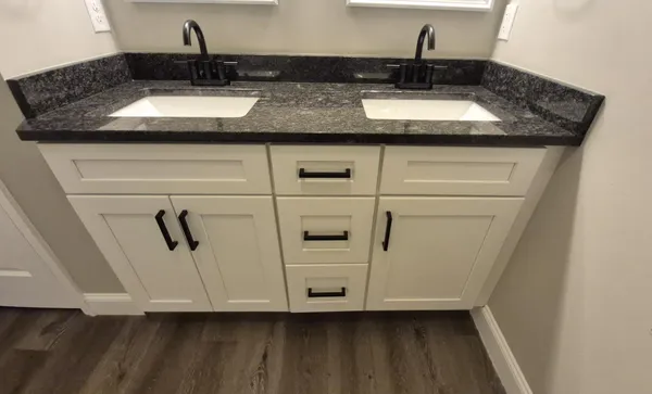 a bathroom with a granite countertop sink and a mirror