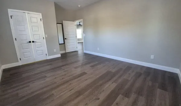 a view of empty room with wooden floor