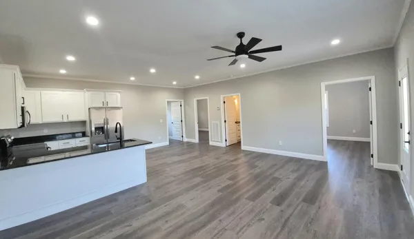 a kitchen with stainless steel appliances granite countertop a sink a stove and a wooden floors