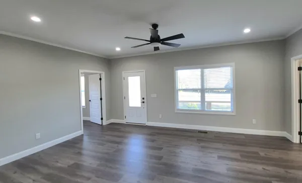 an empty room with wooden floor and windows