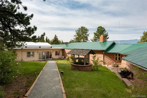 a view of a house with backyard sitting area and garden