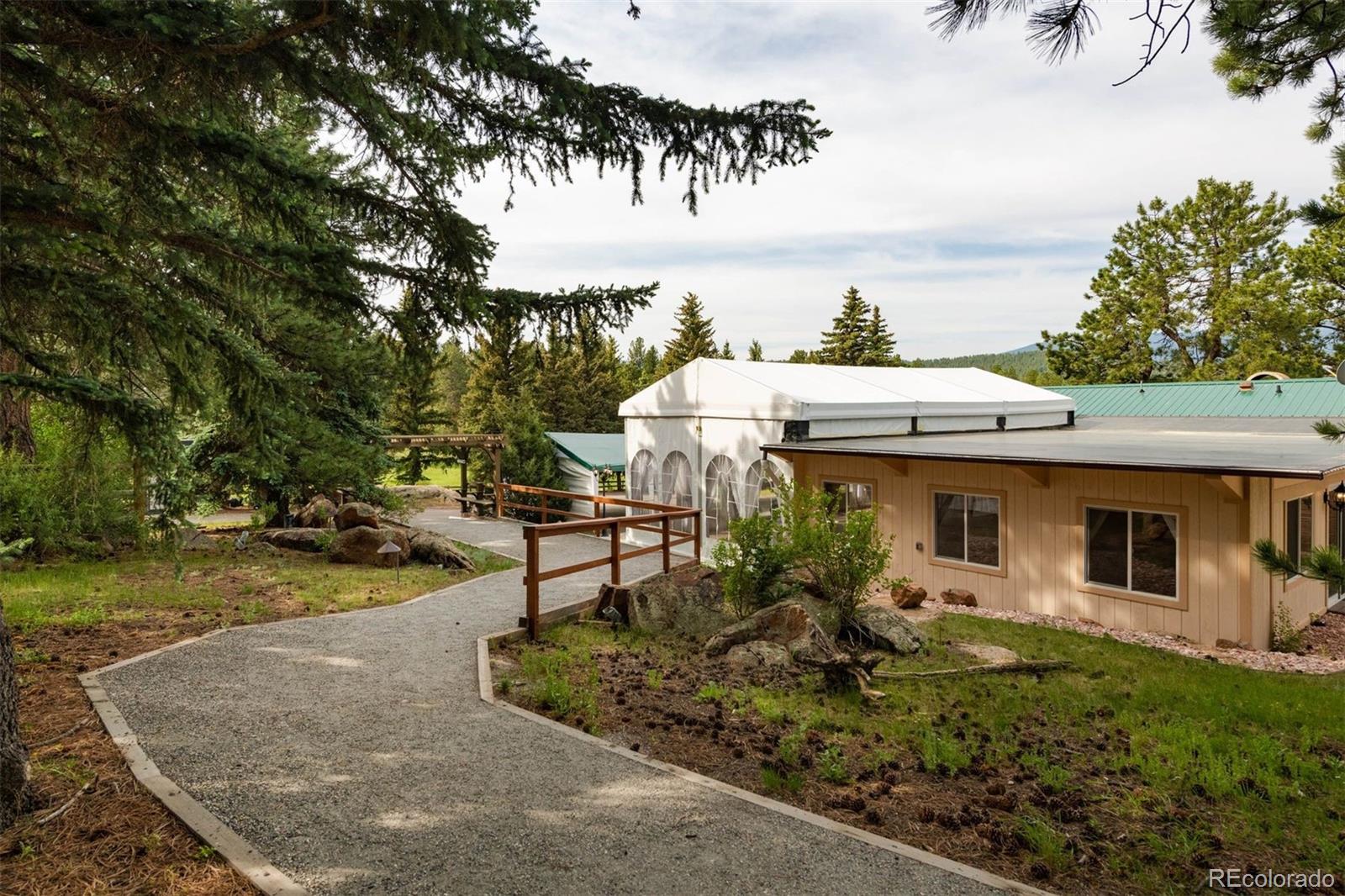 64057 US Highway 285 Bailey, CO 80421 - Photo 30 of 50 a view of a patio with table and chairs potted plants and large tree