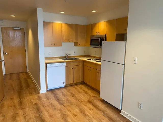 a kitchen with stainless steel appliances granite countertop a refrigerator a sink and a stove