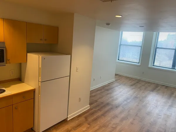a view of a refrigerator in kitchen and wooden floor