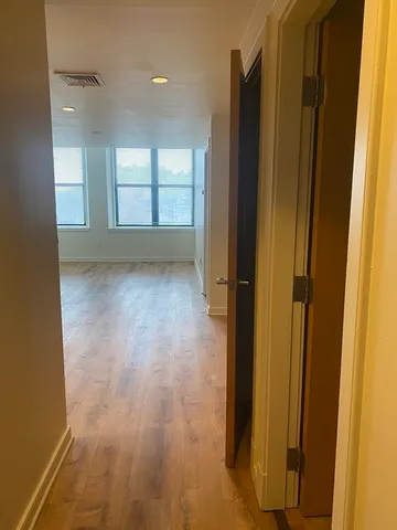 a view of an empty room with window and bathroom