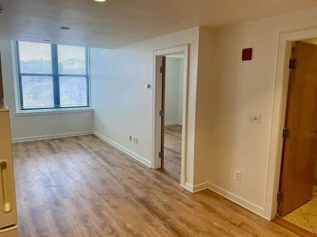 131 Tremont Street, Unit 5B Boston, MA 02111 - Photo 2 of 24 an empty room with wooden floor and windows