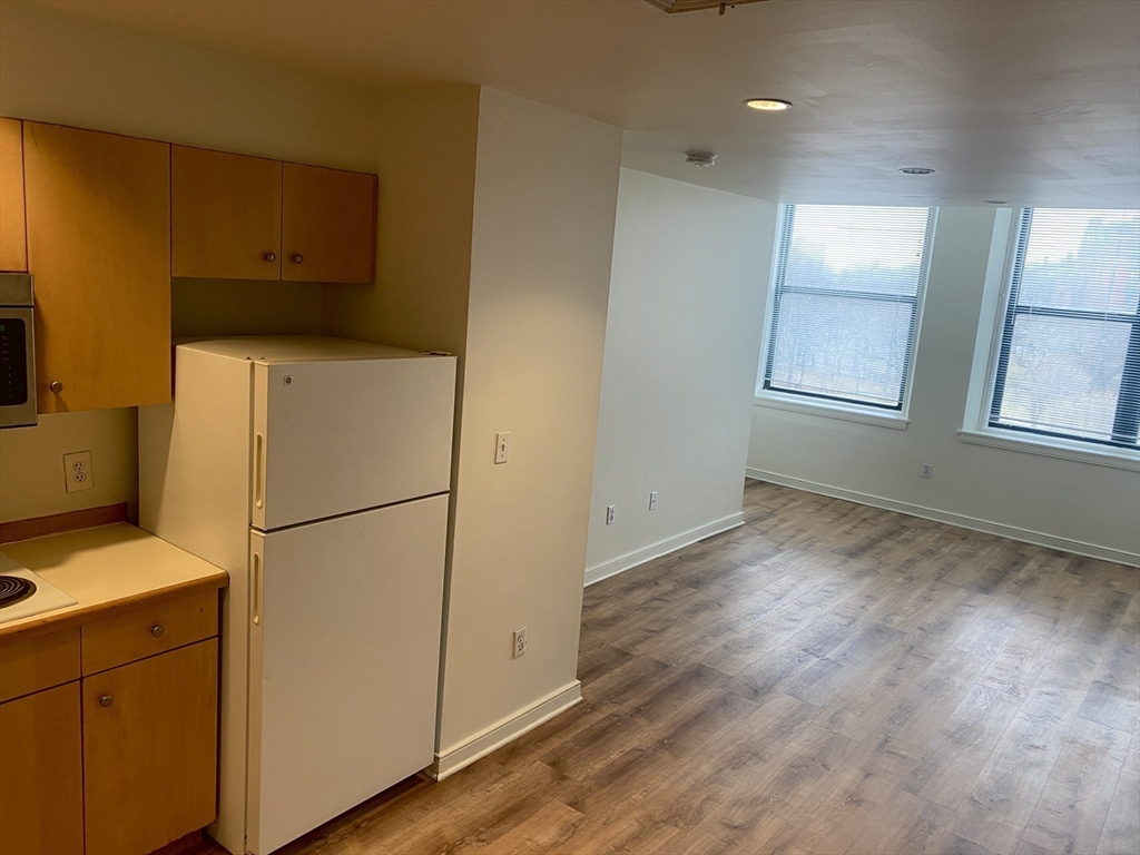 131 Tremont Street, Unit 5B Boston, MA 02111 - Photo 4 of 24 a utility room with wooden floor and electronic appliances