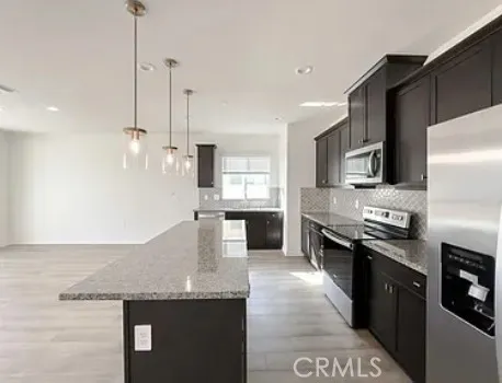 a kitchen with stainless steel appliances granite countertop a sink a stove and a refrigerator