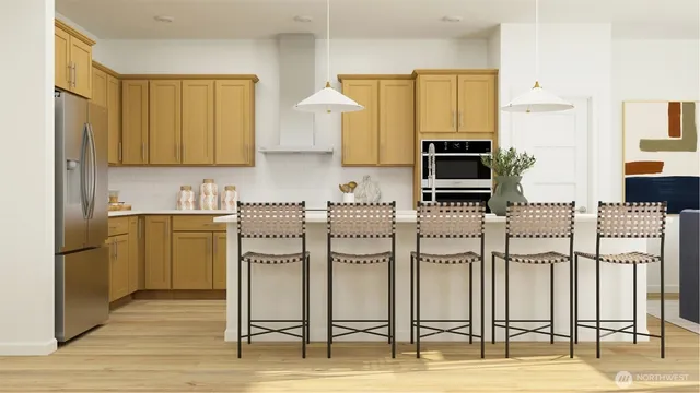 a kitchen with stainless steel appliances kitchen island granite countertop a refrigerator and cabinets