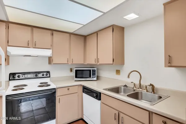 a kitchen with sink a stove and cabinets