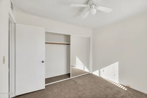 a view of an empty room with a ceiling fan