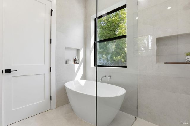 a view of a hallway with wooden floor and a bathroom