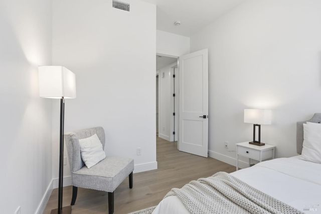 a bedroom with a bed and a painting on the wall