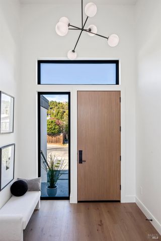 a view of a hallway with wooden floor and a chandelier