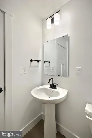 a bathroom with a sink a toilet and a mirror