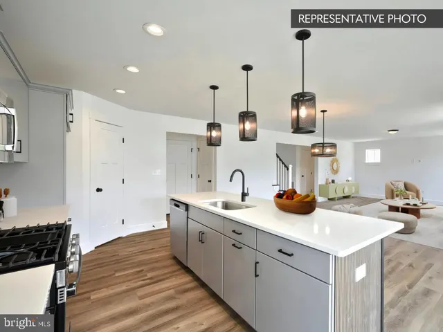 a kitchen with a sink dishwasher and white cabinets with wooden floor