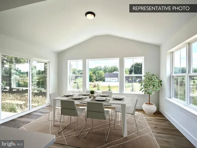 a dining room with furniture and large windows