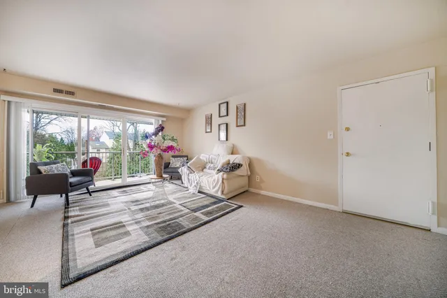 a living room with furniture and a kitchen view