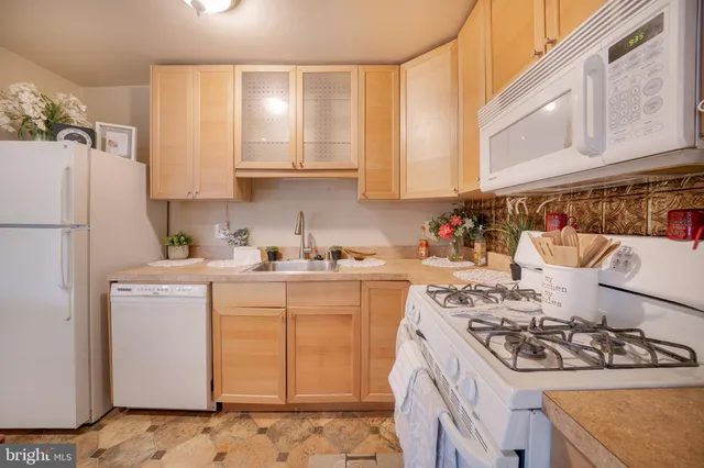 a kitchen with a sink a refrigerator and cabinets
