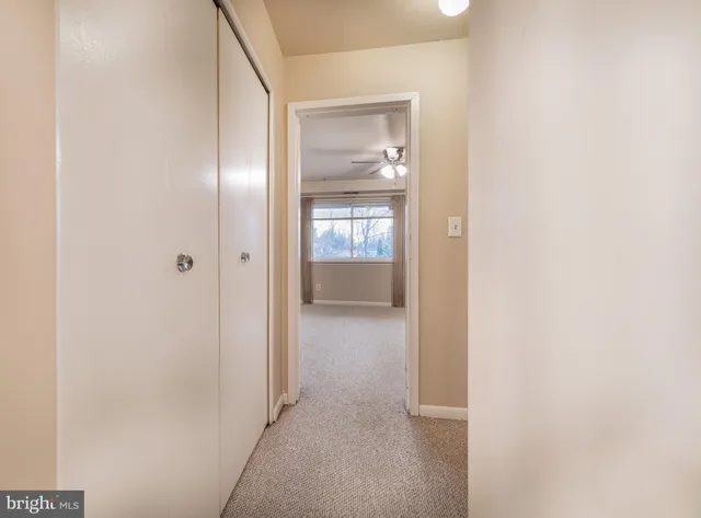 an empty room with a window and a fan