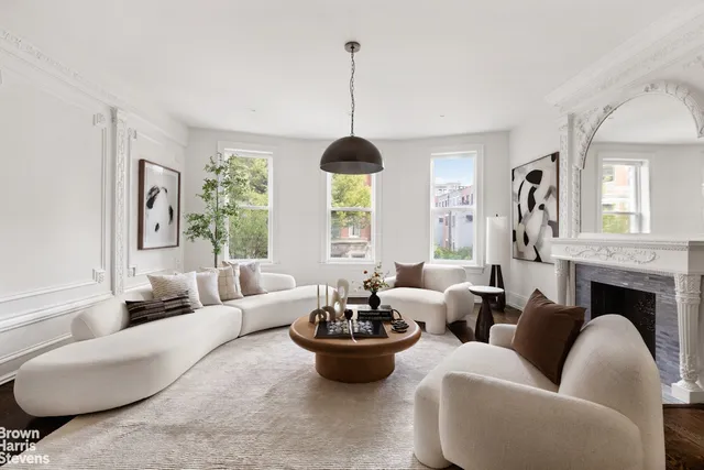 a living room with furniture fireplace and a large window