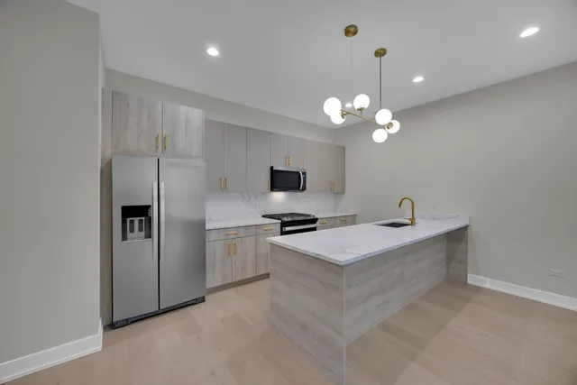 a kitchen with kitchen island a sink stainless steel appliances and cabinets