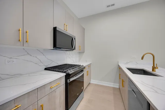 a kitchen with stainless steel appliances granite countertop a sink and a stove top oven with a dishwasher