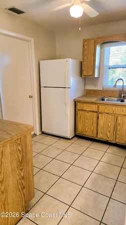 a kitchen with granite countertop a refrigerator a stove a sink and dishwasher
