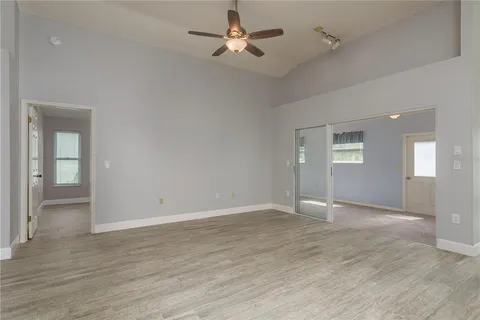 a view of a big room with wooden floor and windows