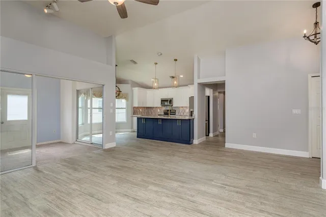 a view of a room with wooden floor and a ceiling fan