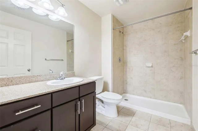 a bathroom with a granite countertop sink toilet and shower