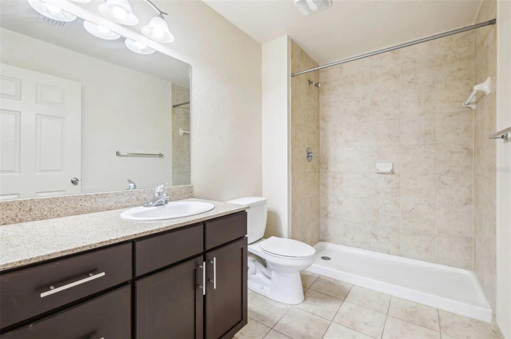 3334 South Bismark Lane, Unit 1B01304 Jupiter, FL 33458 - Photo 19 of 36 a bathroom with a granite countertop sink toilet and shower